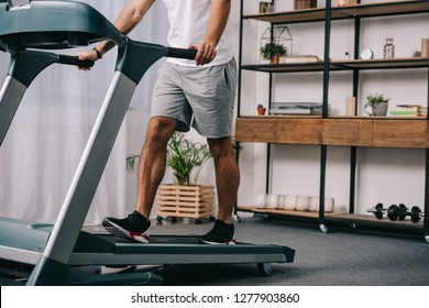 Cropped View Of Man Workout On Treadmill In Living Room