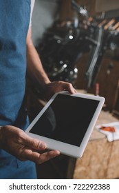 cropped view of mechanic using digital tablet with blank screen