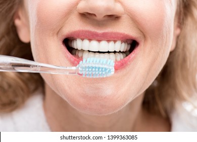 Cropped View Of Middle Aged Woman Brushing Teeth Isolated On White 