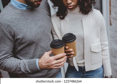 cropped view of multiethnic casual business couple having coffee