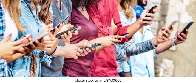 Cropped View On Millenial Hands Using Mobile Smart Phones - People Addicted By Smartphones - Technology Concept With Always Connected Teenagers - Shallow Depth Of Field With Focus On Central Device