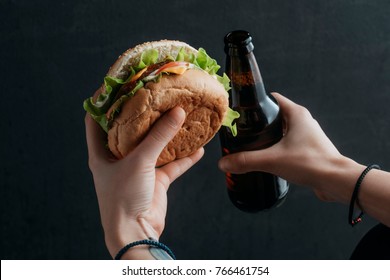 Cropped View Of Person Holding Hamburger And Bottle Of Beer