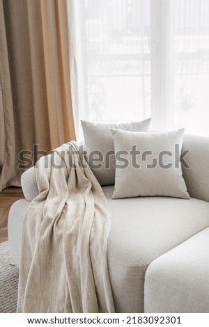 Cropped view of pillows and blanket on modern soft sofa in living room. House after renovation. Relax concept. Home comfort. Apartment interior details. Hotel room