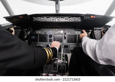 Cropped View Of Pilots Using Yoke And Thrust Lever In Airplane Simulator