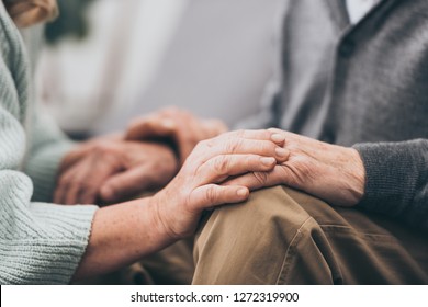 cropped view of retired couple holding hands  - Shutterstock ID 1272319900