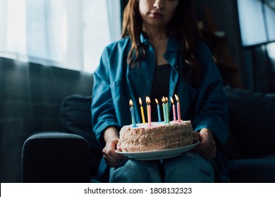 Cropped View Of Sad Woman Holding Birthday Cake With Candles