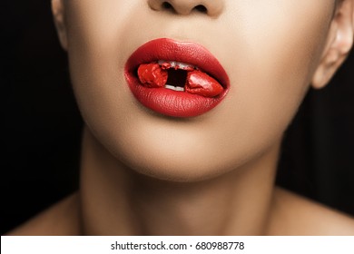 cropped view of seductive woman with red lipstick in mouth, isolated on black  