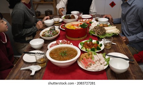 Cropped View Of Senior Host Of Family Grandfather Clapping Hands And Gesturing Members To Sit Down At Dining Table. People Pulling Out Chair. Starting To Eat Big Meal For Chinese New Year