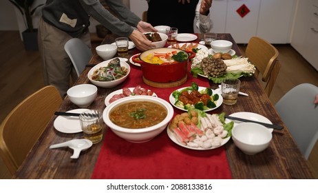 Cropped View Of Senior Host Of Family Grandfather Clapping Hands And Gesturing Members To Sit Down At Dining Table. People Pulling Out Chair, Starting To Eat Big Meal For Chinese New Year