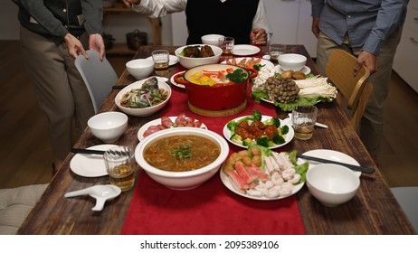 Cropped View Of Senior Host Of Family Grandfather Clapping Hands And Gesturing Members To Sit Down At Dining Table. People Pulling Out Chair, Starting To Eat Big Meal For Chinese New Year