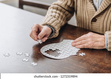 Cropped View Of Senior Man Playing With Puzzles 