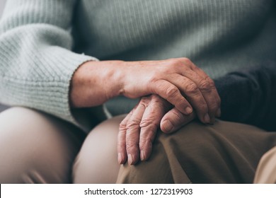 cropped view of senior woman holding hands with retired husband 