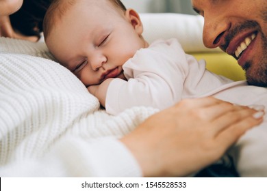 Cropped View Of Smiling Father Leaning On Adorable Baby Lying On Mothers Hands