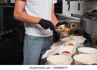 Cropped View Of Social Worker In Latex Gloves Holding Bowl With Prepared Food Near Plastic Containers