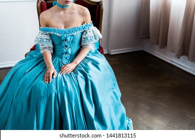 Cropped View Of Victorian Woman Sitting On Antique Chair 