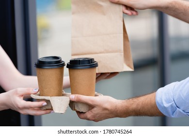 Cropped View Of Waitress Giving Coffee To Go And Paper Bag To Customer Near Cafe On Urban Street