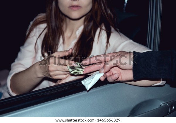 cropped view of woman in car with dollar banknotes\
buying drugs from thug 