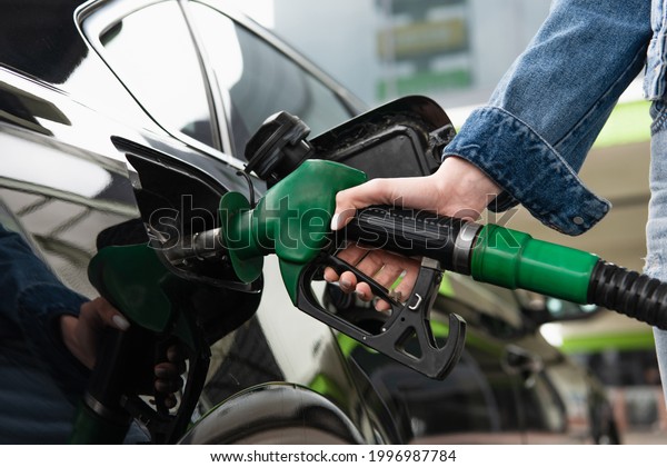 cropped view of\
woman fueling car on gas\
station