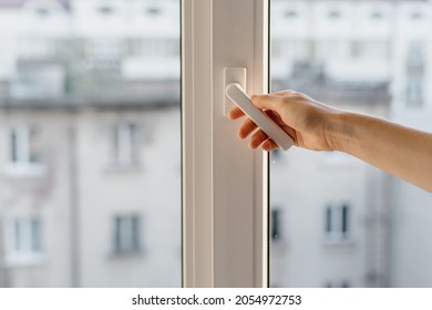 Cropped view woman hand open pvc window and double glazing  Concept noise cancellation   airing the room