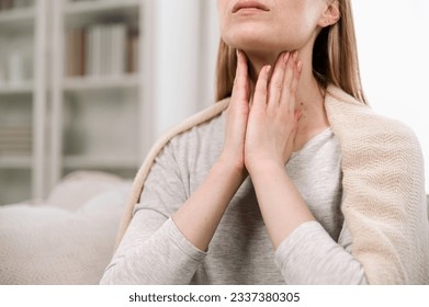 Cropped view of woman hands touching lymph nodes on throat. Self-examination and palpation thyroid glands. Having pain or scratchy sensation - Powered by Shutterstock