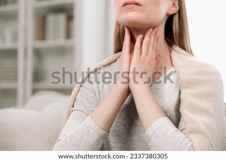 Cropped view of woman hands touching lymph nodes on throat. Self-examination and palpation thyroid glands. Having pain or scratchy sensation