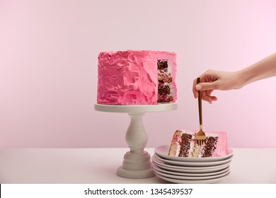 Cropped View Of Woman Holding Golden Fork In Piece Of Sweet Birthday Cake In White Saucer On Pink