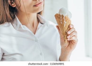 Cropped View Of Woman Holding Melting Ice Cream In Cone