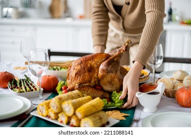 cropped view of woman serving roasted turkey near grilled corn and asparagus for thanksgiving dinner