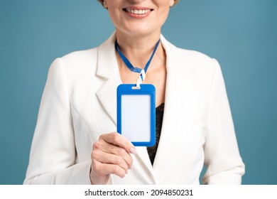 Cropped View Of The Woman Showing Her Blank Vertical ID Badge Mockup, Standing Isolated. Person Identity Label. Senior Woman In Shirt Uniform With Empty Id Card Mock Up 