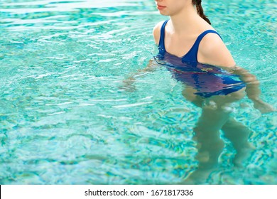 Cropped view of woman swimming in swimming pool