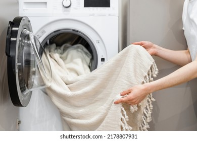 Cropped view of woman unloading laundry from white washing machine. Tulle cleansing. Cleaning service worker. Concept of purity. Housekeeping idea