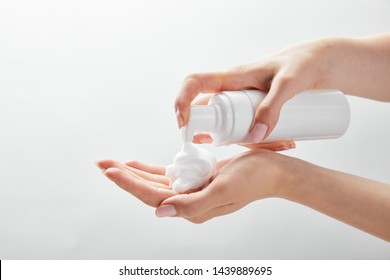 Cropped View Of Woman Using Cosmetic Dispenser With Foam Isolated On White