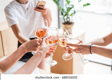 cropped view of women clinking with wineglasses with pink wine - Powered by Shutterstock