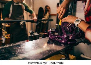 Cropped View Of Worker Screwing Snowboard Binding To Snowboard In Repair Shop