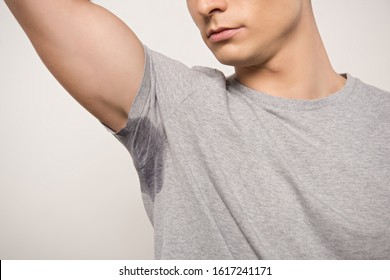 Cropped View Of Young Man In Grey T-shirt With Sweaty Underarm Isolated On Grey