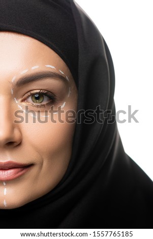 cropped view of young Muslim woman in hijab having marks on face for plastic surgery isolated on white