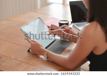 Cropped view of a young student using a pen on a tablet to present his university admission.
