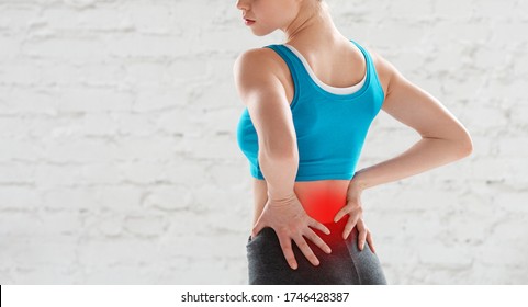 Cropped View Of Young Woman Feeling Pain In Her Lower Back After Workout At Gym, Copy Space. Panorama