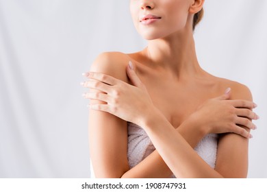 cropped view of young woman touching bare shoulders on white