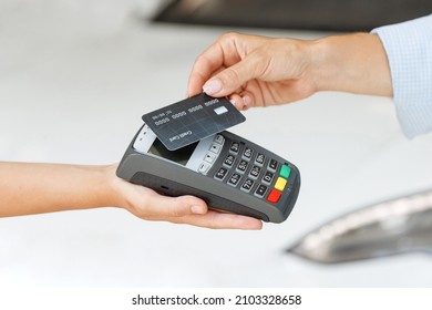 Cropped woman customer buyer client female hand hold wireless bank payment terminal process acquire credit card payments buy automobile in car showroom vehicle salon dealership store motor show indoor