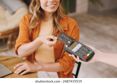 Cropped woman hold bank payment terminal to process acquire credit card pay bill sitting alone at table in coffee shop cafe relax rest at restaurant indoor. Freelance mobile office business concept - Powered by Shutterstock - Get 15% off with code: PIKWIZARD15