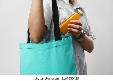 Cropped Woman Holding Fabric Shopping Bag And Juice Bottle, Studio Shot, Close Up