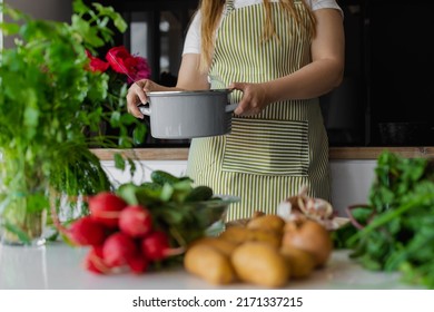 Cropped Woman With Pan On Background. Fresh Vegetables As Cook Ingredients On The Table. Greenery, Radish, Potato, Beetroot. Recipe Of Healthy Soup Or Salad. Diet And Healthy Organic Eco Food At Home