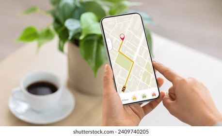 Cropped of woman using navigation mobile app on smartphone, using tracking service, order taxi online. Unrecognizable lady drinking coffee at home, waiting for cab, panorama
