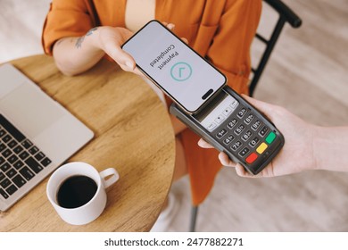 Cropped young woman hold bank payment terminal to process acquire mobile cell phone pay bill sits alone at table in coffee shop cafe relax rest at restaurant indoor. Freelance office business concept - Powered by Shutterstock