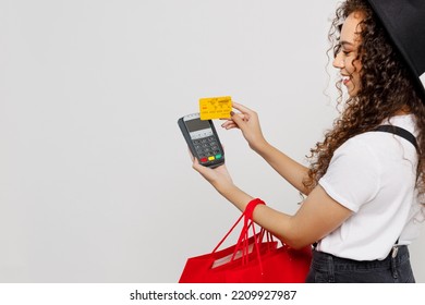 Cropped young woman wear t-shirt hat hold red package bags after shopping bank payment terminal process acquire credit card isolated on plain solid white background. Black Friday sale buy day concept - Shutterstock ID 2209927987
