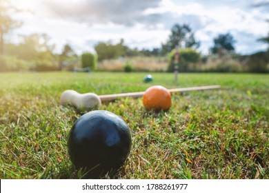 Croquet outdoor game on a lawn in the summer with a mallet and colorful balls