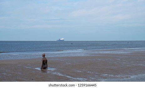 Crosby, England - November 6, 2018: The beach in north Liverpool, known as Another Place, where one hundred iron casts of the body of sculptor Anthony Gormley are partially submerged along the coast