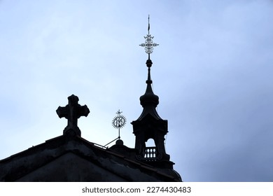 Cross and belfry silhouette in front of cloudy sky in Catholic church in Shrine of our Lady Trsat