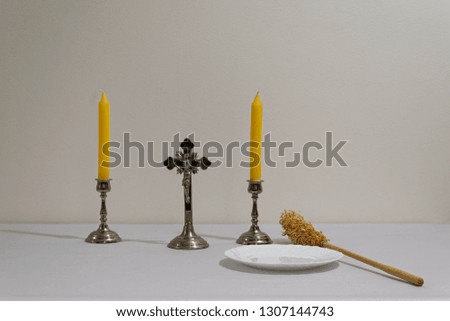 Cross, candles and sprinkler prepared before priest visitation.